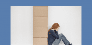 woman sitting with moving boxes, holding her head and looking overwhelmed, with MMC logo