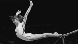 Nadia Comeneci on the parallel bars in a black and white photo