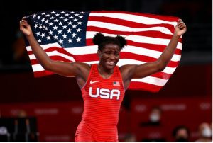 Olympic athlete Tamyra Mensah-Stock running with the American flag