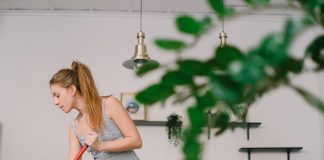 Friday Favorites: Five Things Saving My Sanity in 2022 woman sweeping a house with a green plant in the foreground