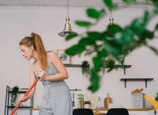 Friday Favorites: Five Things Saving My Sanity in 2022 woman sweeping a house with a green plant in the foreground