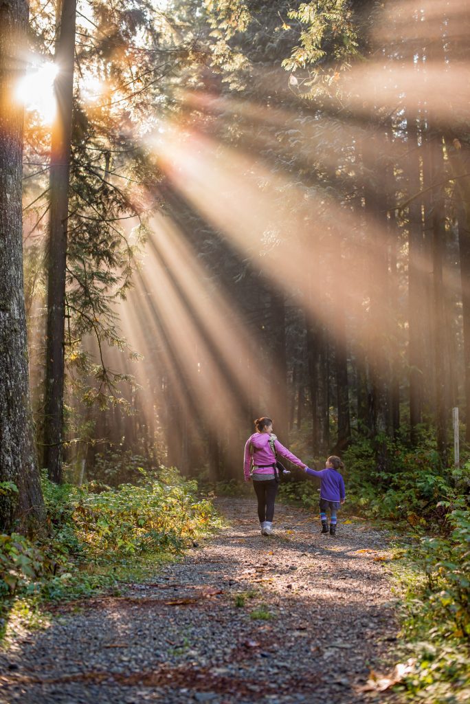 mother and child walking together in a forest