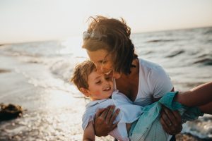 mom and son playing in the ocean