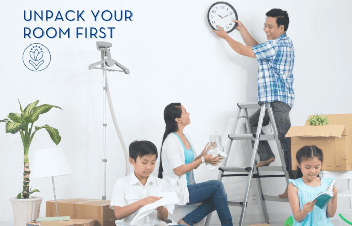 Unpack Your Room First family unpacking a house with Dad hanging a clock. "Unpack Your Room First" in text and MMC logo