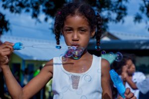 girl in pigtails blowing bubbles