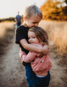 two small children hugging in a field