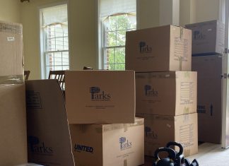 Cardboard moving boxes are stacked up at the door.