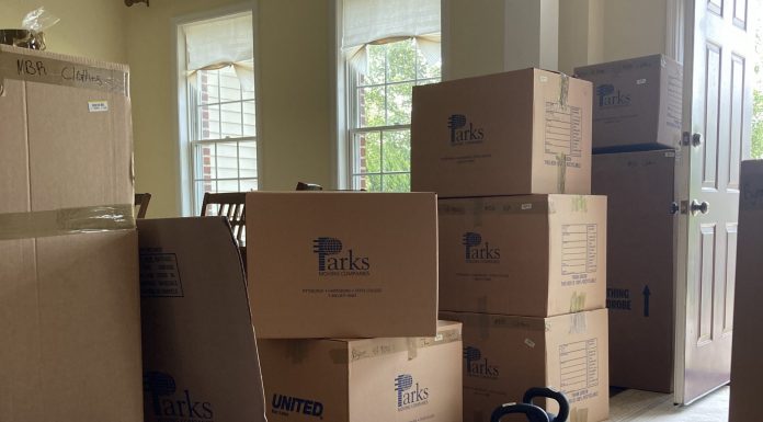 Cardboard moving boxes are stacked up at the door.