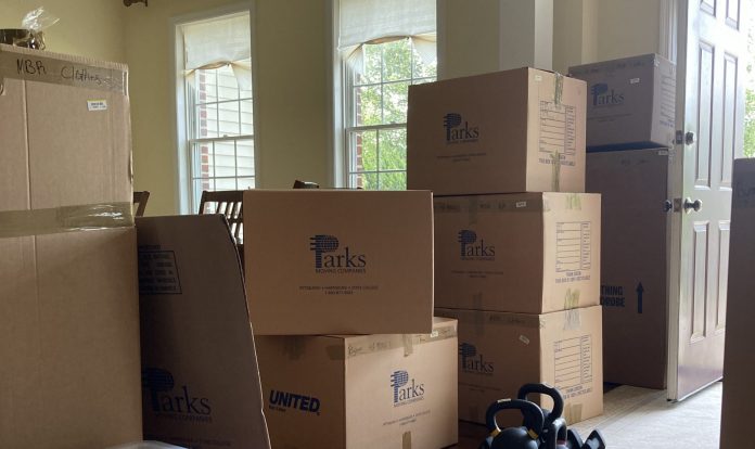 Cardboard moving boxes are stacked up at the door.