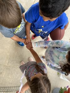 Kids huddle before a game of flag football