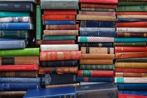 Many different colors of books, stacked horizontally