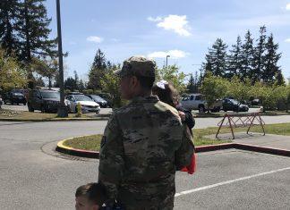 Soldier walking with children in arms