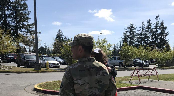 Soldier walking with children in arms