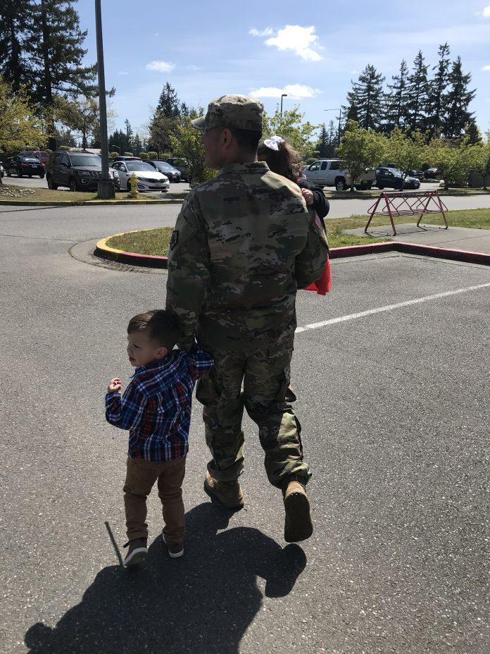 Soldier walking with children in arms