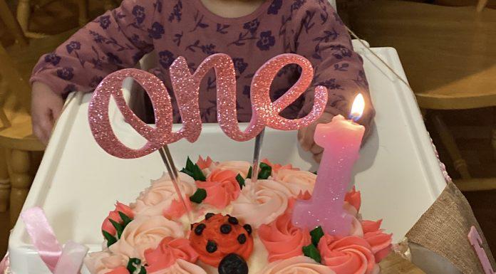 Birthday cake with 1 candle and the word one.