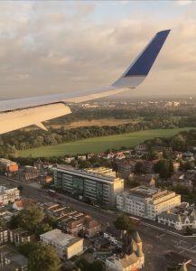 The wing of a plane is see as the plane flies over the countryside of southern England.