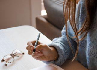 Woman writing on planner notebook