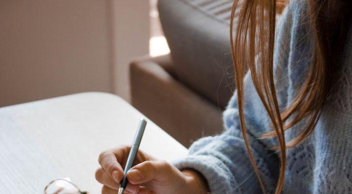 Woman writing on planner notebook