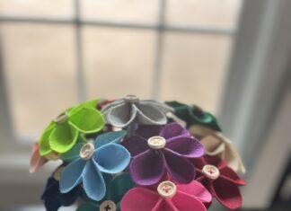 Multicolored bouquet of felt flowers with wooden button centers in a white flower pot