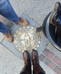 Feet standing around Freedom Trail marker