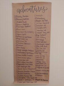 brown craft paper titled "Adventures" with a checklist written on it