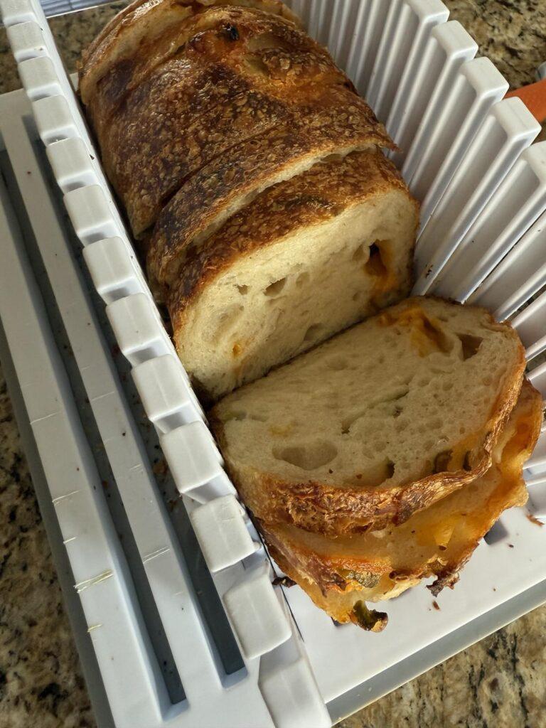 Sourdough cheddar bread in a bread cutting rack