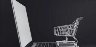 PCS and Purchases: Why I Spend Like a Maniac After Every Move Tiny shopping cart on a laptop keyboard, perfectly capturing that post PCS “I swear this is the last thing I need” online shopping spiral.