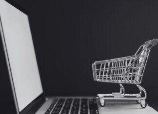 Tiny shopping cart on a laptop keyboard, perfectly capturing that post PCS “I swear this is the last thing I need” online shopping spiral.