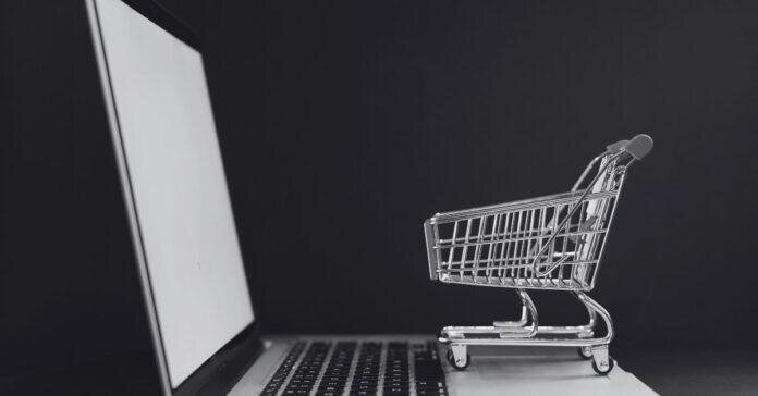 Tiny shopping cart on a laptop keyboard, perfectly capturing that post PCS “I swear this is the last thing I need” online shopping spiral.