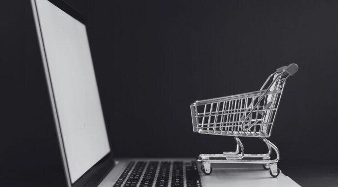 PCS and Purchases: Why I Spend Like a Maniac After Every Move Tiny shopping cart on a laptop keyboard, perfectly capturing that post PCS “I swear this is the last thing I need” online shopping spiral.