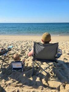Man and child sitting on the beach in Cape Cod