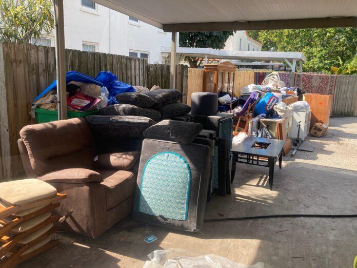 Furniture Pile After Hurricane Helene furniture pile along gate of flooded items ready for trash pickup