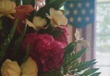 Emotional Wellness for Military Moms: A Gentle October Reset A fresh boutique of wildflowers with a soft American flag and bright window backdrop to represent a renewed emotional state.