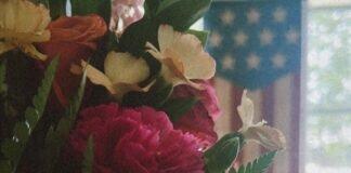 Emotional Wellness for Military Moms: A Gentle October Reset A fresh boutique of wildflowers with a soft American flag and bright window backdrop to represent a renewed emotional state.