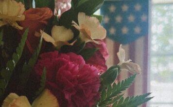 Emotional Wellness for Military Moms: A Gentle October Reset A fresh boutique of wildflowers with a soft American flag and bright window backdrop to represent a renewed emotional state.