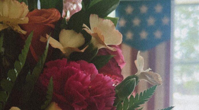 Emotional Wellness for Military Moms: A Gentle October Reset A fresh boutique of wildflowers with a soft American flag and bright window backdrop to represent a renewed emotional state.