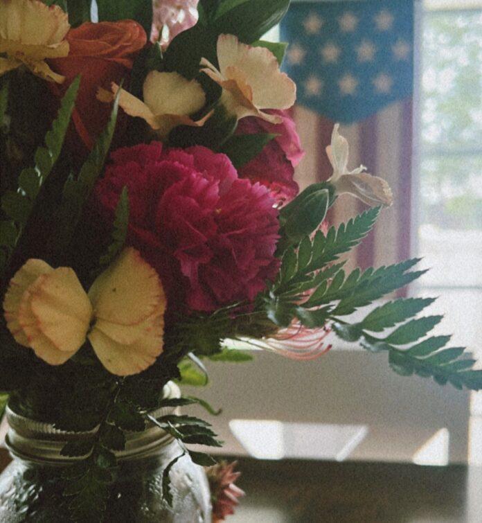 Military Moms Emotional Wellness A fresh boutique of wildflowers with a soft American flag and bright window backdrop to represent a renewed emotional state.