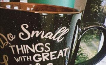 The Invisible Load of Supporting Love, Duty and Ambition A coffee mug that reads "do small things with great love" sitting next to an open laptop