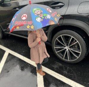 A little girl walking in the rain with her umbrella