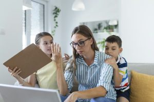 Overwhelmed mother attempting to work while her children demands her attention