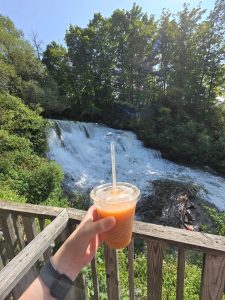 Apple cider slushie with waterfall in the background
