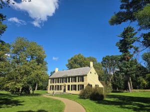 1700s yellow farmhouse with blue skies overhead