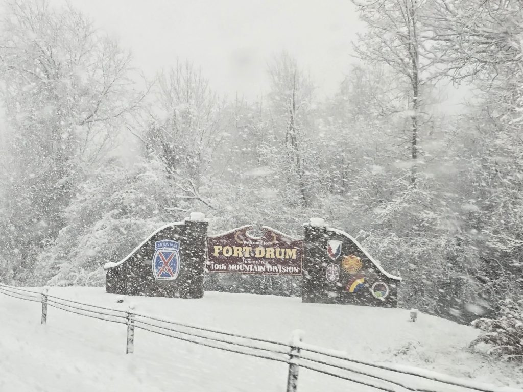 Welcome to Fort Drum sign with snow falling