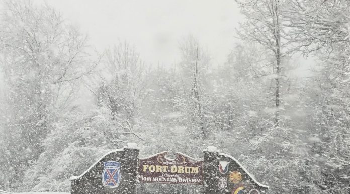 Welcome to Fort Drum sign with snow falling