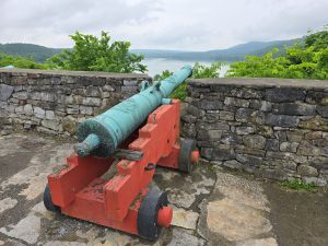 Historic cannon with mountain lake in background