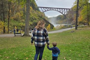 Woman and child walking towards waterfall